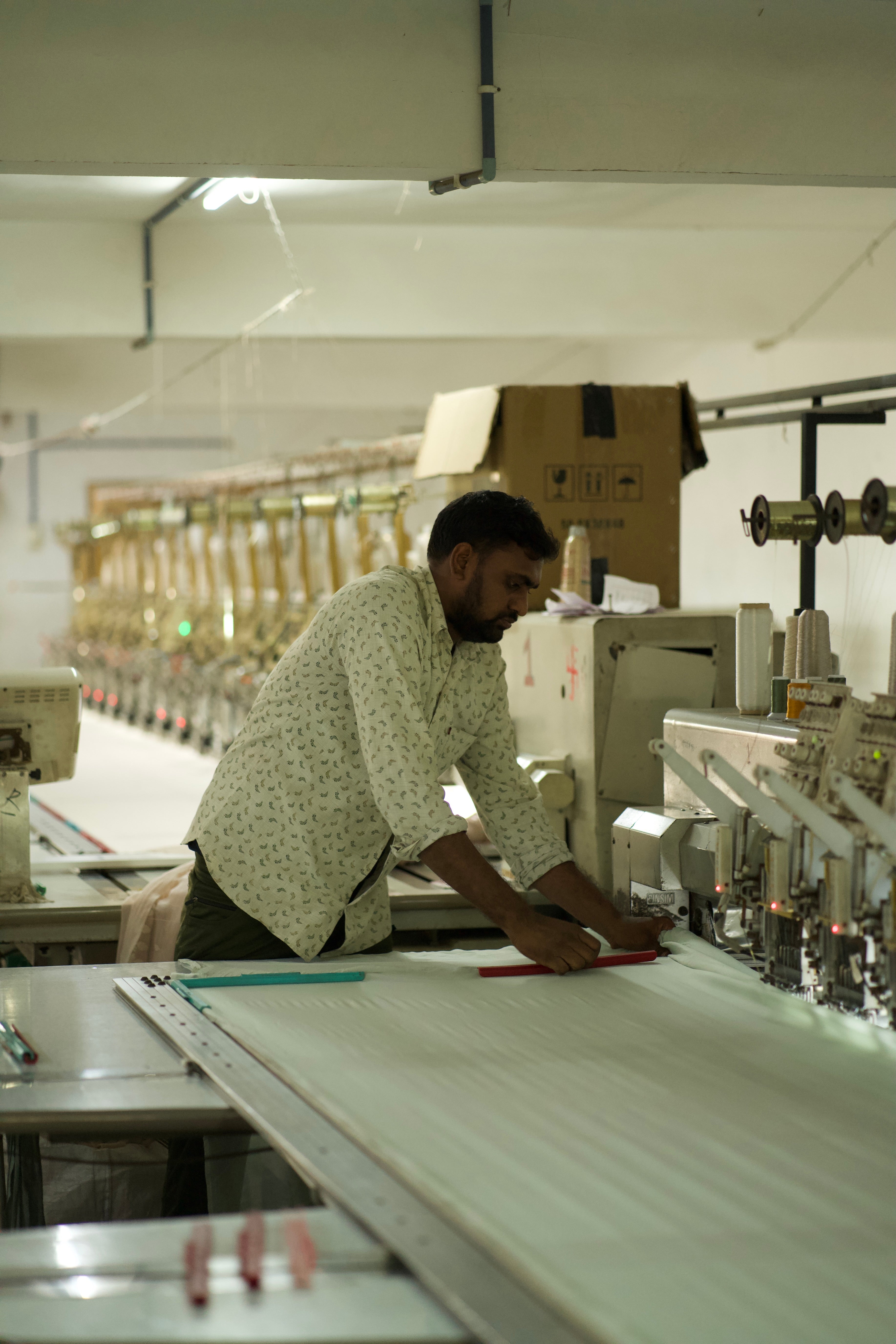 Person working at a sewing machine in a factory setting